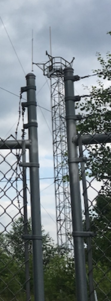 The southwest tower with two surviving vertical whip antennas held out on support arms