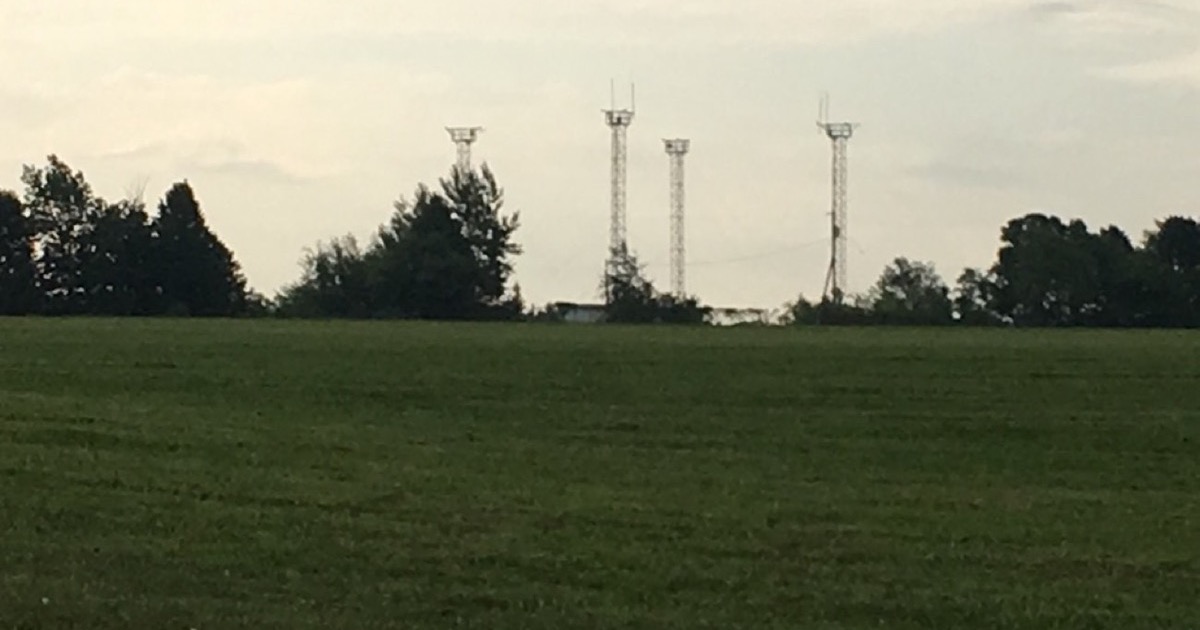 Four steel lattice towers on the horizon of a Wisconsin farm field